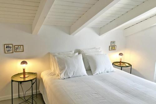 een slaapkamer met een wit bed en 2 lampen op tafels bij Casa Dona Ana in Tavira