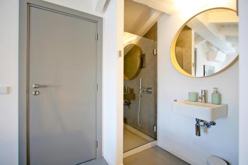 een badkamer met een douche, een wastafel en een spiegel bij Casa Dona Ana in Tavira
