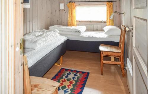 a small room with two beds and a chair at Ulv - Hytte 3 in Øvre Ramse