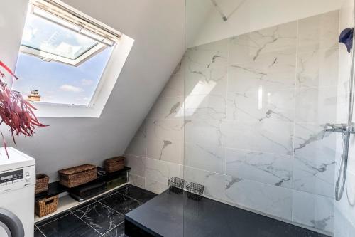 a bathroom with a shower with a marble wall at Paris Centre Dernier Étage Vue Ascenseur in Paris