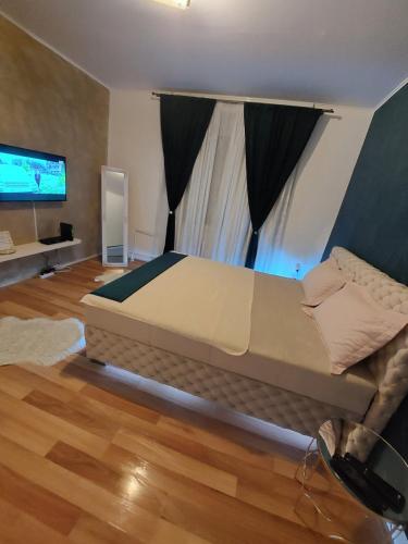un grande letto in una stanza con televisore di Creative studio 4 a Novi Sad