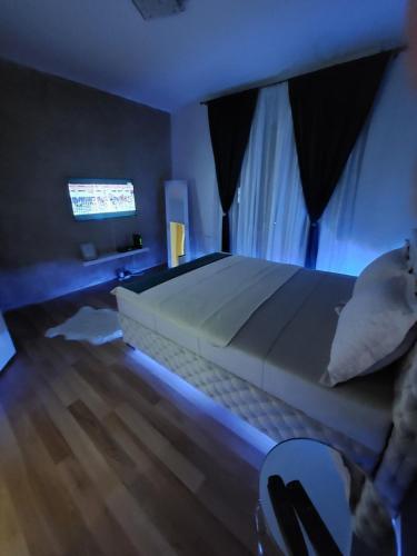ein Schlafzimmer mit einem großen Bett mit blauer Beleuchtung in der Unterkunft Creative studio 4 in Novi Sad