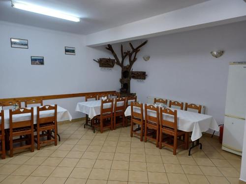 a dining room with tables and chairs and a tree on the wall at Pensiunea Ana Cristina in Sighişoara