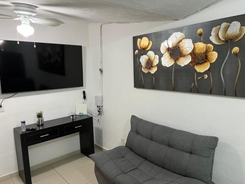 sala de estar con sofá y TV de pantalla plana en Casa Chito, en Colima
