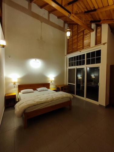 a bedroom with a large bed and a large window at Ziran retreat in Mukteswar