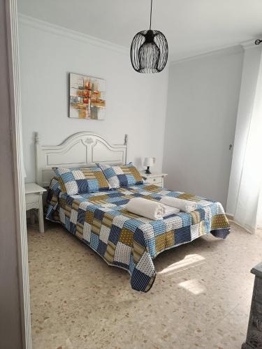 um quarto com uma cama com um cobertor xadrez em PISO EN 2* LINEA DE PLAYA em Barbate