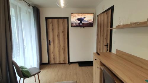 a room with a door and a tv on the wall at Willa Magdalena in Sromowce Niżne