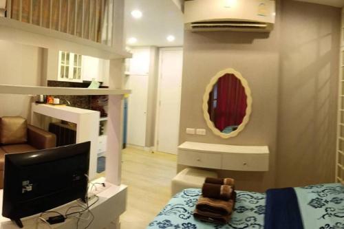 a bedroom with a computer and a mirror on the wall at Fluffy bed and seaview @Bangsaen in Ban Bang Saen (1)