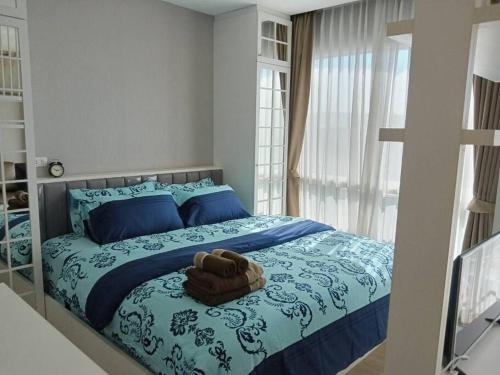 een slaapkamer met een bed met blauwe lakens en blauwe kussens bij Fluffy bed and seaview @Bangsaen in Ban Bang Saen (1)