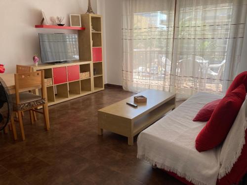 a living room with a bed and a table and a television at Apartamento Las Chumberas in Roquetas de Mar