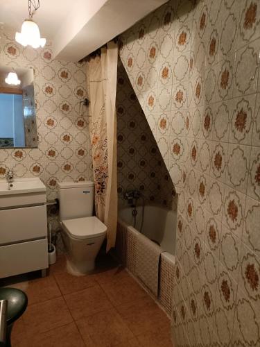 a bathroom with a toilet and a sink and a tub at Apartamento o Casa Rural Roquemar in Guijo de Granadilla