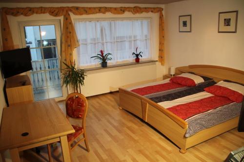 a bedroom with a bed and a table and a window at Ferienwohnung mit 4 Schlafzimmer für 2 bis 9 Gäste----Apartment with 4 bedrooms for 2 to 9 guests in Nuremberg