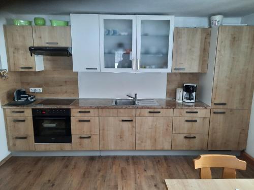 a kitchen with wooden cabinets and a sink at Seehof Royer in Obertraun