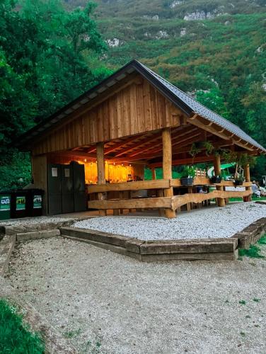 a large wooden building with a roof at Glamping Gozdna Jasa in Bovec