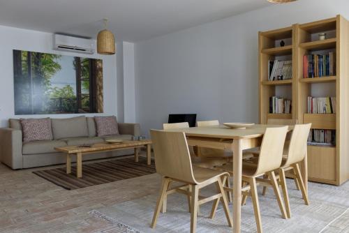 a living room with a wooden table and chairs at Casa Valerie - Etramures in Tavira