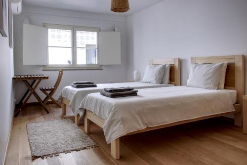 a bedroom with two beds and a window at Casa Valerie - Etramures in Tavira