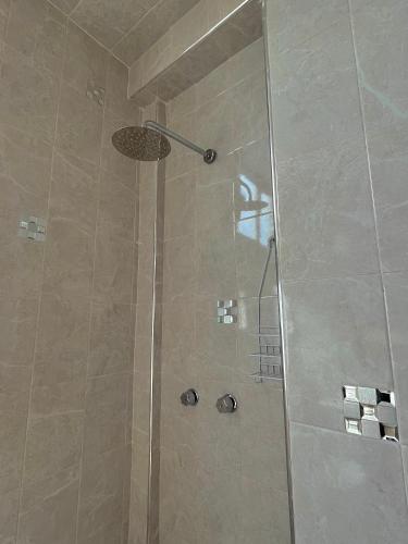 y baño con ducha y puerta de cristal. en OYO Hotel Museo Carnaval, en Huejotzingo