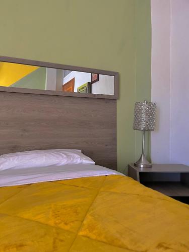 - une chambre avec un grand lit et une lampe dans l'établissement OYO Hotel Museo Carnaval, à Huejotzingo