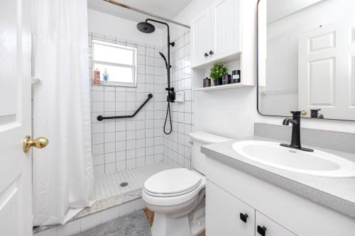 a white bathroom with a toilet and a sink at Blue Heron Lakeview Pool Home Close to Clearwater in Largo