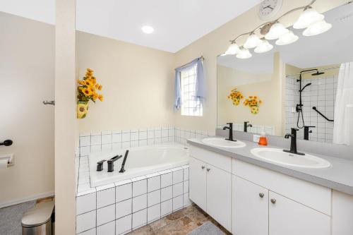 a white bathroom with two sinks and a tub at Blue Heron Lakeview Pool Home Close to Clearwater in Largo