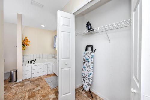 a bathroom with a white door and a sink at Blue Heron Lakeview Pool Home Close to Clearwater in Largo