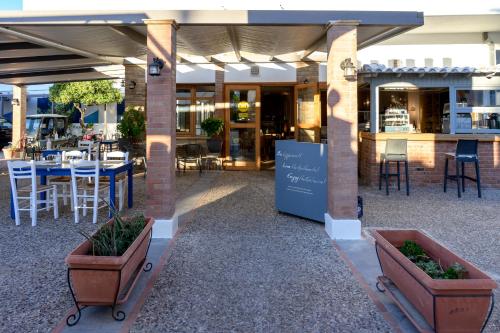 a restaurant with two potted plants and a table and chairs at Chios Xenia Studios & Apartments in Paralia Agias Foteinis
