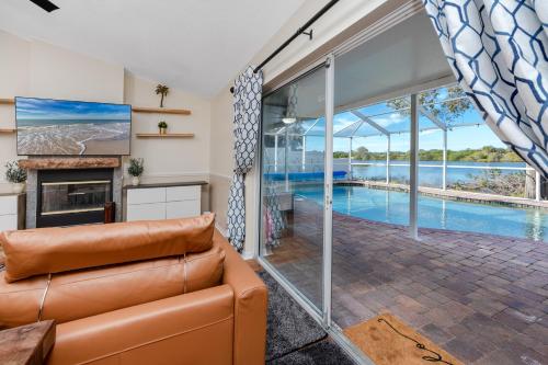 a living room with a couch and a swimming pool at Blue Heron Lakeview Pool Home Close to Clearwater in Largo