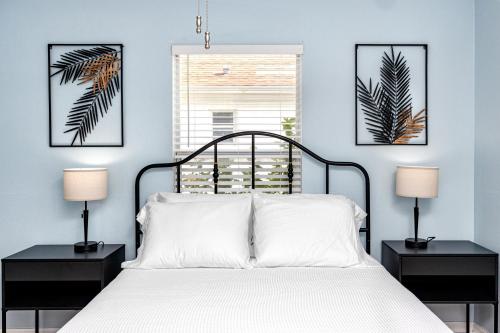 een slaapkamer met een wit bed en 2 nachtkastjes bij Blue Heron Lakeview Pool Home Close to Clearwater in Largo