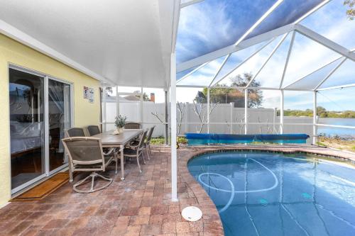 a patio with a table and a swimming pool at Blue Heron Lakeview Pool Home Close to Clearwater in Largo