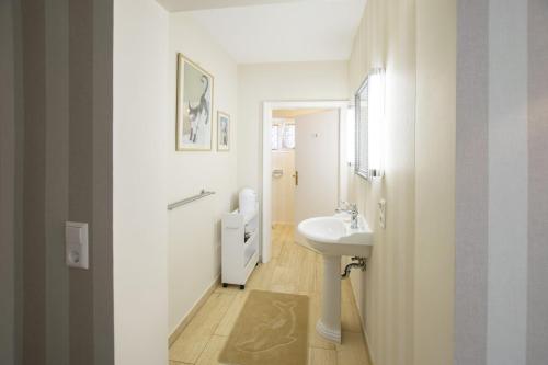 a white bathroom with a sink and a toilet at Peace-Deluxe**** in Bingen am Rhein