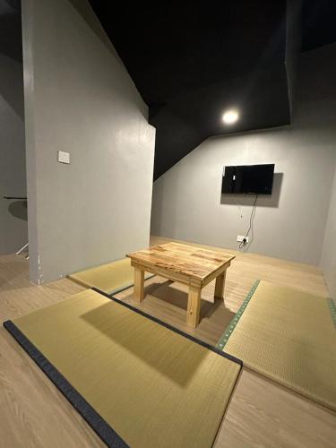 a wooden table in a room with two mats at Tatami D'Tepi Laut - PANGKOR ISLAND in Pangkor