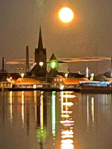 a reflection of a church in the water at night at Byens Bed and Bath in Nakskov