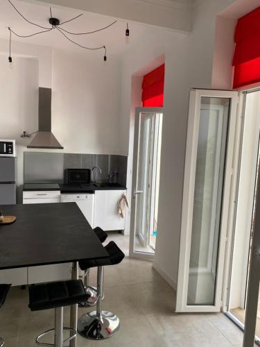 - une cuisine avec des plafonds rouges, une table et des chaises dans l'établissement LE CAMAS, à Marseille