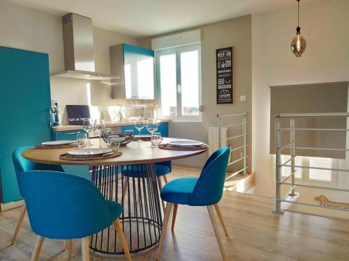 馬翁普拉日堡的住宿－Superbe apt cosy à 500m de la plage pour 4 pers，一间厨房,内设一张桌子和蓝色的椅子