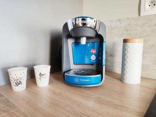 una cafetera sentada en un mostrador con dos tazas en Superbe apt cosy à 500m de la plage pour 4 pers en Fort-Mahon-Plage