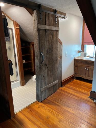 an open wooden door in a room with a bathroom at Eduard Haus on 5th Street in Hermann