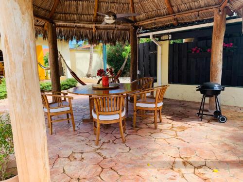 un patio con mesa, sillas y parrilla en Casa Opal en Palm-Eagle Beach