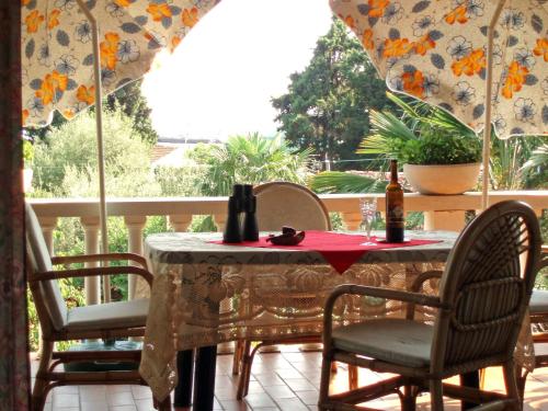 un tavolo con sedie e una bottiglia di vino sul portico di Dasen a Umag (Umago)