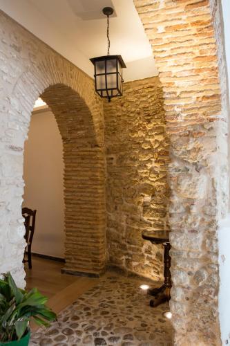 a room with a stone wall and aendant light at Hotel Tugasa Casa Palacio Medina Sidonia in Medina Sidonia