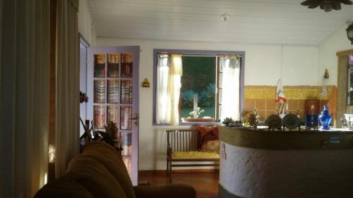 1 cama individual en una sala de estar con ventana en Pousada Quinta Bela Vista - Raízes, en Caeté
