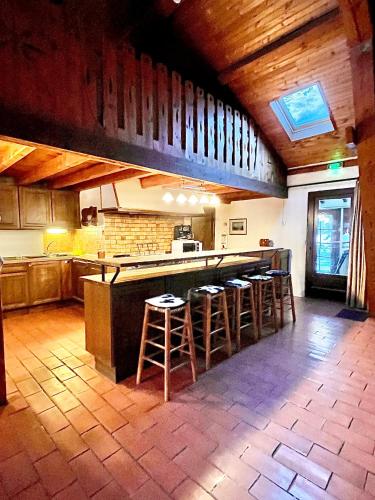 une cuisine avec un bar et des tabourets. dans l'établissement Gîte du Soula, à Mérens-lès-Vals