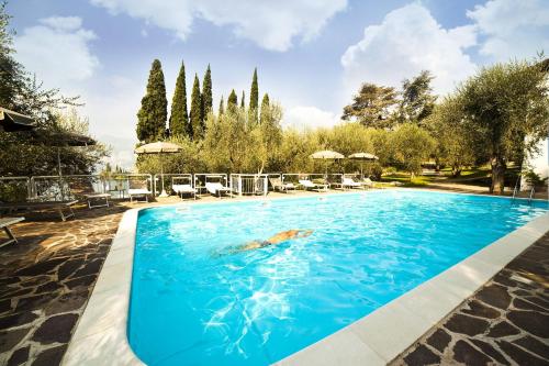 una piscina con una persona nadando en el agua en Hotel Villa Orizzonte, en Malcesine