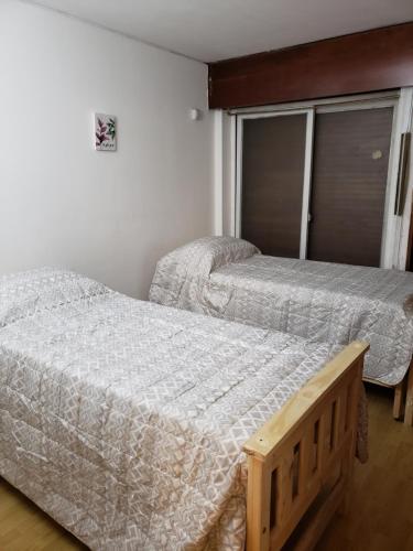 1 dormitorio con 2 camas y ventana en Departamento ubicadisimo calle Chile con estacionamiento incluido capital Mendoza 4 en Mendoza