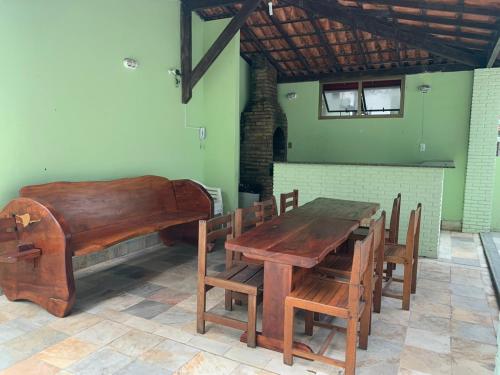 a dining room with a wooden table and a piano at Barra Apart Service in Salvador