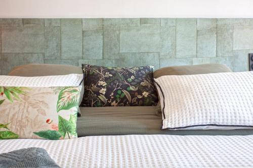 un lit avec deux oreillers dessus dans l'établissement Maison en pierre Corse avec vue proche des Gorges de l'Asco entre mer montagne et piscine, à Moltifao