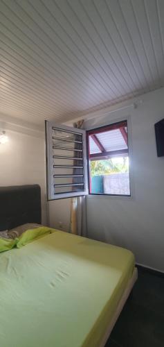 a small bedroom with a bed and a window at Suite de charme avec jacuzzi à 5min de l'aéroport in Les Abymes