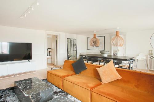 a living room with a couch and a table at Modern 3BR Duplex Apartment in Nyhavn w Private Balcony in Copenhagen