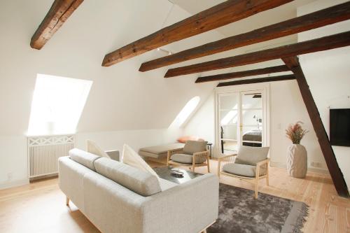 a living room with a white couch and chairs at Modern 3BR Duplex Apartment in Nyhavn w Private Balcony in Copenhagen