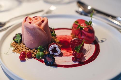 ein Dessert auf einem weißen Teller auf einem Tisch in der Unterkunft Sensoria Dolomites in Seis am Schlern