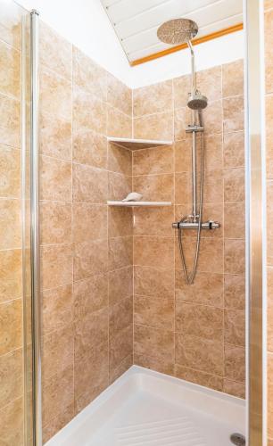 a shower with a glass door in a bathroom at Kis Teniszház in Ordacsehi